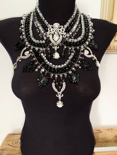 There is a timeless elegance a regal superiority. This is a little sparkly, perfect shade of black and will make you shine! This choker has exquisite rhinestones,in combination with premium black and silver crystal beads Also in this style https://www.etsy.com/listing/666529914/silver-chain-maskslave-braceletsilver?ref=shop_home_active_78&cns=1 Elegant Jeweled Crystal Bib Necklace, Glamorous Bib Necklace With Rhinestones, Glamorous Beaded Crystal Bridal Necklace, Evening Bridal Necklace With Jeweled Crystals, Glamorous Crystal Bib Necklaces, Elegant Crystal Bib Necklaces For Weddings, Glamorous Rhinestone Bib Necklace, Glamorous Beaded Bridal Necklace For Party, Crystal Embellished Necklaces For Wedding