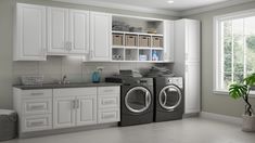 a washer and dryer in a room with white cabinets, counter tops and drawers