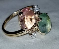 VINTAGE 14K YELLOW GOLD NATURAL PINK & BLUE TOURMALINE RING SET CENTER TWO NATURAL TOURMALINE IN OVAL CABOCHON SHAPE WEIGHT 5.12 CARAT SIZE 9.7X7.7MM GORGEOUS PINK & GREEN TOURMALINE AAA RATED!! VERY CLEAN ,VERY NICE CUT ,AMAZING BRILLIANCE FULL OF FIRE, SPARKLY. SIDE SET TWO ROUND NATURAL DIAMONDS WEIGHT 0.20CT H-SI1 RING size 7 Resizable Retail value $4,500 net. Appraisal available Vintage Tourmaline Ring For Anniversary, Vintage Tourmaline Anniversary Ring, Platinum Engagement Rings Vintage, Round Diamond Ring, Best Engagement Rings, Blue Tourmaline, Platinum Engagement Rings, Tourmaline Ring, White Gold Engagement