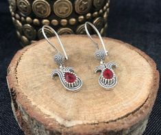 Our filigree women's earrings Tulip Filigree Women's Earrings with Red Stone are made of  925 sterling silver.  Specially oxidized to achieve the authentic look. Weight; 4.8g Size: approx 3.9cm x 1.2cm Our company started its activities in 2019, has recently decided to open the silver jewelery which is produced highly qualified and in a unique style with the filigree technique at the local level, to the world markets and has started its activities for this purpose. Researches by archaeologists reveal that silver jewelry has been accepted as an indispensable product since ancient times. Again, researches reveal that people have produced ideas on silver jewelry and produced different techniques for jewelry making throughout history. One of the most striking of these techniques is the filigre Red Sterling Silver Filigree Earrings, Ornate Red Sterling Silver Earrings, Best Gifts For Her, Wire Wrapped Earrings, Sterling Silver Dangle Earrings, Victorian Jewelry, Delicate Earrings, Red Stone, Silver Earrings Dangle