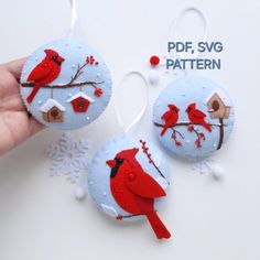 two ornaments with red birds on them and snowflakes