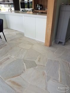 a kitchen with stone flooring and white cabinets