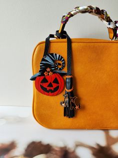 an orange purse with a halloween decoration on it