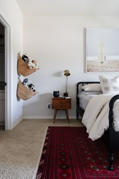 a bedroom with a bed, rug and pictures on the wall