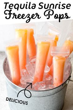 tequila sunrise freeze pops in a bucket with ice