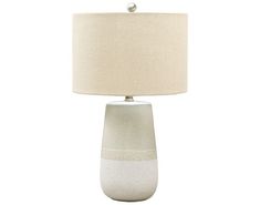 a white table lamp with a beige shade on the base and a light bulb in the middle