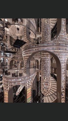 a spiral staircase made out of books in the middle of a room filled with stairs