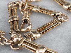 "This antique chain was originally used to hold a pocket watch, but it also makes a gorgeous choker necklace! The links are superbly crafted, with wire spirals and sleekly polished bars of 14 karat gold. This is a weighty, impressive piece and could also be worn double wrapped as a bracelet! Metal: 14K Yellow Gold Width of Chain: 7 mm Length of Chain: 13.5 Inches Marks: \"A\" Stamped on the clasp To view a video of this piece check out the link below: https://vimeo.com/579554515 SKU #: 16ZD2LNM Victorian Link Necklaces With Curb Chain, Victorian Style Necklace With Curb Chain Link, Victorian Link Jewelry With Curb Chain, Victorian Curb Chain Necklaces, Victorian Curb Chain Link Jewelry, Victorian Style Curb Chain Link Necklace, Antique Curb Chain Necklaces For Formal Occasions, Antique Curb Chain Necklace For Formal Occasions, Antique Curb Chain Necklace With Oval Links