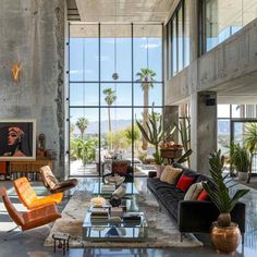 a living room filled with lots of furniture and large glass windows on the wall next to it