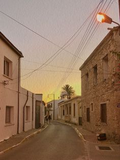 an empty street with two buildings on both sides and a traffic light hanging over the road