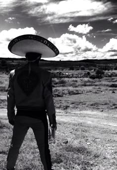 a man with a sombrero on his head standing in the middle of nowhere