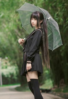 a young woman holding an umbrella in the rain