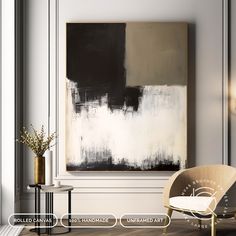 an abstract painting hangs on the wall next to a chair and table in a white room