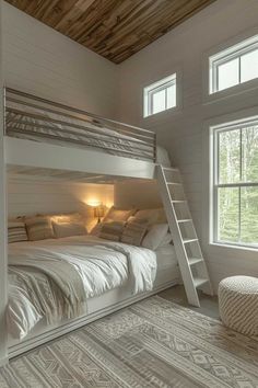 a bunk bed in a room with white walls and wood ceilinging, along with two windows