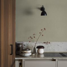 a kitchen counter with a vase on it and a lamp hanging from the ceiling above