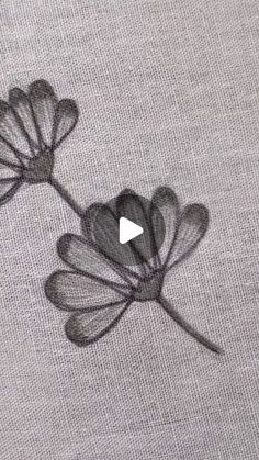 an embroidered flower is shown on the side of a piece of fabric with black thread