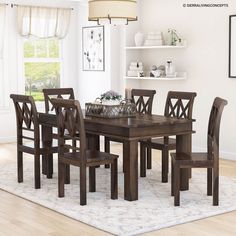 a dining room table and chairs in front of a white wall with shelves on it