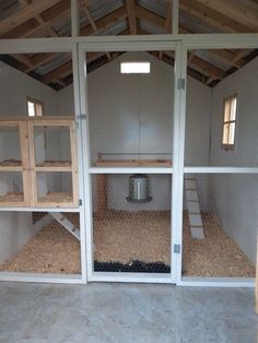 the inside of a chicken coop with two doors open