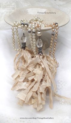 Boho Bridal Tassel Necklace, Boho Chic Pearl Necklace, Sari Silk Tassel Statement Necklace A gorgeous hand made, hand - knotted Sari Silk Tassel with vintage faux pearls . Features antique rhinestones, a large faceted crystal , vintage Czech transparent glass vintage faux pearls and a beautiful hand made ivory Sari Silk tassel This necklace is so beautiful ... So elegant and so unique .... The antique rhinestones , the Silk tassel and the vintage pearls create a luxurious and vintage atmosphere Elegant Latkans Necklace As A Gift, Elegant White Necklace With Latkans, Elegant Handmade Dangle Tassel Necklace, Elegant Handmade Tassel Necklace With Round Beads, Elegant Tassel Necklace With Round Beads As Gift, Silk Tassel Necklace, Tassel Necklace Boho, Shabby Chic Jewelry, Bridal Pearl Necklace