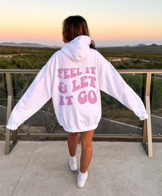 Introducing our groovy and empowering "Feel It And Let It Go" Mental Health Hoodie! Designed to embrace the journey of emotions and encourage mindfulness, this hoodie combines a cute and preppy style with a retro-inspired, groovy font that proudly displays the words on the back. Crafted with care, this mental health sweatshirt is made from high-quality materials, ensuring both comfort and durability. Its cozy fabric keeps you warm and snug, while its trendy hoodie style offers a comfortable and Casual Relaxed Fit Hoodie With Screen Print, Trendy White Sweats For Leisure, Athleisure Hoodie With Graphic Print For Leisure, Athleisure Graphic Print Hoodie For Leisure, White Letter Print Hoodie Sweats, White Hooded Sweats With Letter Print, White Hooded Letter Print Sweats, Trendy Cotton Hoodie For Leisure, Trendy Letter Print Hoodie For Leisure