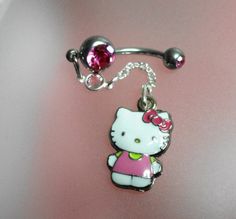 a hello kitty belly ring with a pink bow on it's head and a silver ball chain