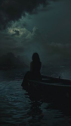 a woman sitting in the water on top of a boat under a dark sky with clouds