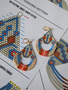 two pairs of beaded earrings sitting on top of a piece of paper next to each other