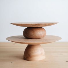 three wooden plates stacked on top of each other in the middle of a wood table