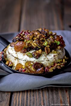 a cake with nuts and other toppings sitting on top of a black platter