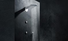 a black and white photo of a shower head with the light shining on it's side