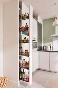 an organized pantry in a kitchen with white cabinets and flooring is seen from the doorway