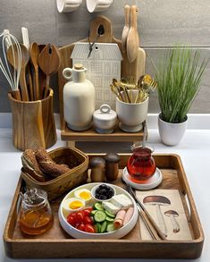 a wooden tray topped with lots of different types of food and cooking utensils