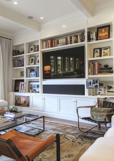 a living room filled with furniture and a flat screen tv mounted on a wall above a fireplace