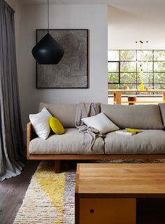 a living room filled with furniture next to a wooden table and large painting on the wall