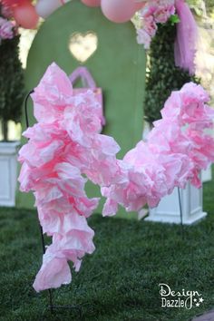 some pink tissue paper flowers in the grass