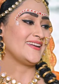 a woman with makeup and jewelry on her face