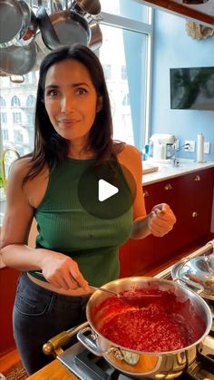 a woman standing in front of a pan filled with food on top of a stove