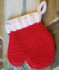 a crocheted red and white stocking hanging on a doorknott