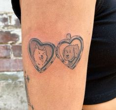 a woman's arm with two pictures of dogs in heart shaped frames on it