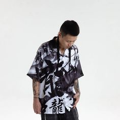 Experience the perfect fusion of street style and casual comfort with our Dragon Calligraphy Cuban Half Shirt. This shirt features an all-over print of calligraphy artwork, exuding a unique and edgy street vibe. The addition of ink splatter prints adds depth and character to the design. A single pocket adorns the left chest, offering both style and functionality. With half sleeves and a Cuban collar, this shirt strikes the perfect balance between modern and retro aesthetics. Crafted from premium Spring Printed Streetwear Tops, Spring Streetwear Printed Tops, Printed Tops For Spring Streetwear, Spring Casual Hawaiian Shirt With Graphic Print, Hip Hop Style Graffiti Print Tops For Spring, Hip Hop Tops With Graffiti Print For Spring, Black Camp Collar Top With All Over Print, Black Camp Collar Top With Print, Streetwear Graphic Print Shirt For Spring