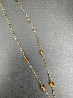 "A lovely Art Deco era 14K gold and citrine drop necklace. The citrine briolette drop is a sunny yellow color and measures an impressive 34 mm long by 17 mm wide by 11.4 mm deep. The many facets around the entire stone allows it to really shine. It has some natural inclusions as well as some minor surface abrasions as shown in the photos. The citrine is suspended from a delicate filigree necklace with citrine bead stations. Lovely open gold work on each gold panel. The clasp is stamped \"14K\" f Yellow Gold Briolette Gemstone Drop Necklace, Formal Faceted Citrine Necklaces, Elegant Citrine Briolette Necklace, Hallmarked Citrine Pendant Necklace, Yellow Citrine Briolette Necklace, Stacked Diamond Bands, Filigree Necklaces, Citrine Beads, Snake Ring