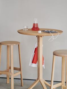 a table with two stools next to it and a red object on the table