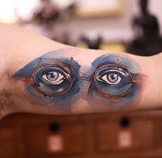 an eyeball tattoo on the left side of the upper half of the arm is shown