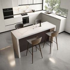 a modern kitchen with white counter tops and black accents on the cabinets, along with two stools