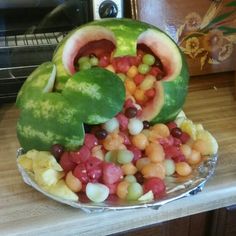 a watermelon shaped like a face with fruits and vegetables in it