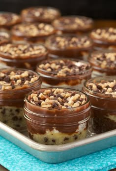 there are many desserts in small glass jars on the tray, ready to be eaten