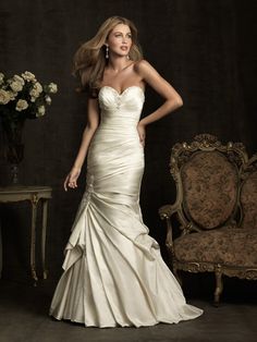 a woman in a wedding dress standing next to a chair with flowers on the table