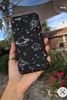 a person holding up a phone case with space and stars on it