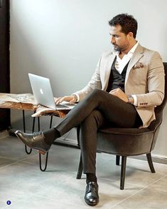 a man sitting in a chair using a laptop computer