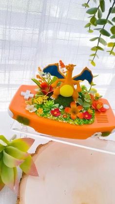 an orange plastic tray with plants and animals on it